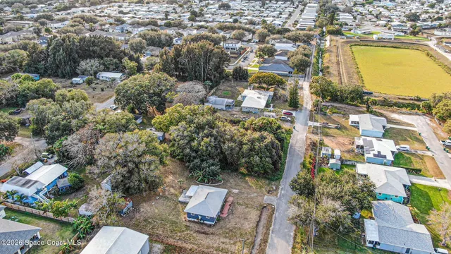 an aerial view of residential houses with outdoor space and swimming pool