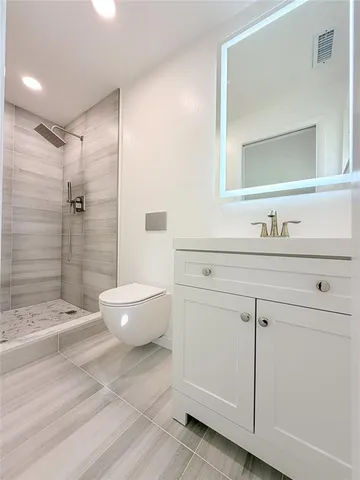a bathroom with a sink toilet a mirror and shower