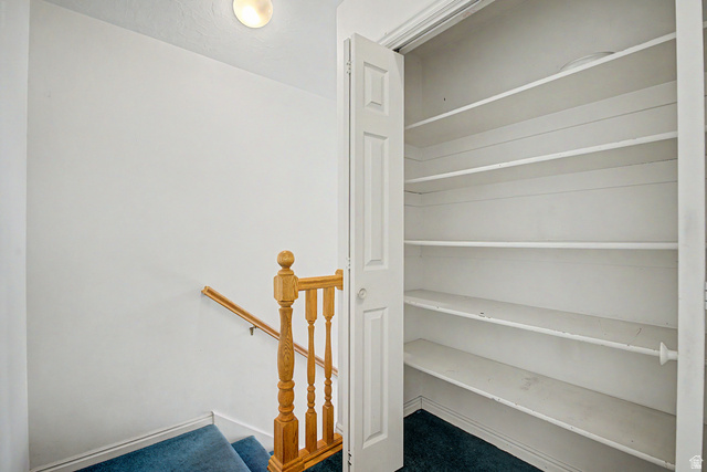2058 California Avenue, Unit 2 Provo, UT 84606 - Photo 25 of 32 Reach-in closet with multiple white storage shelves, bi-fold door, and blue carpet