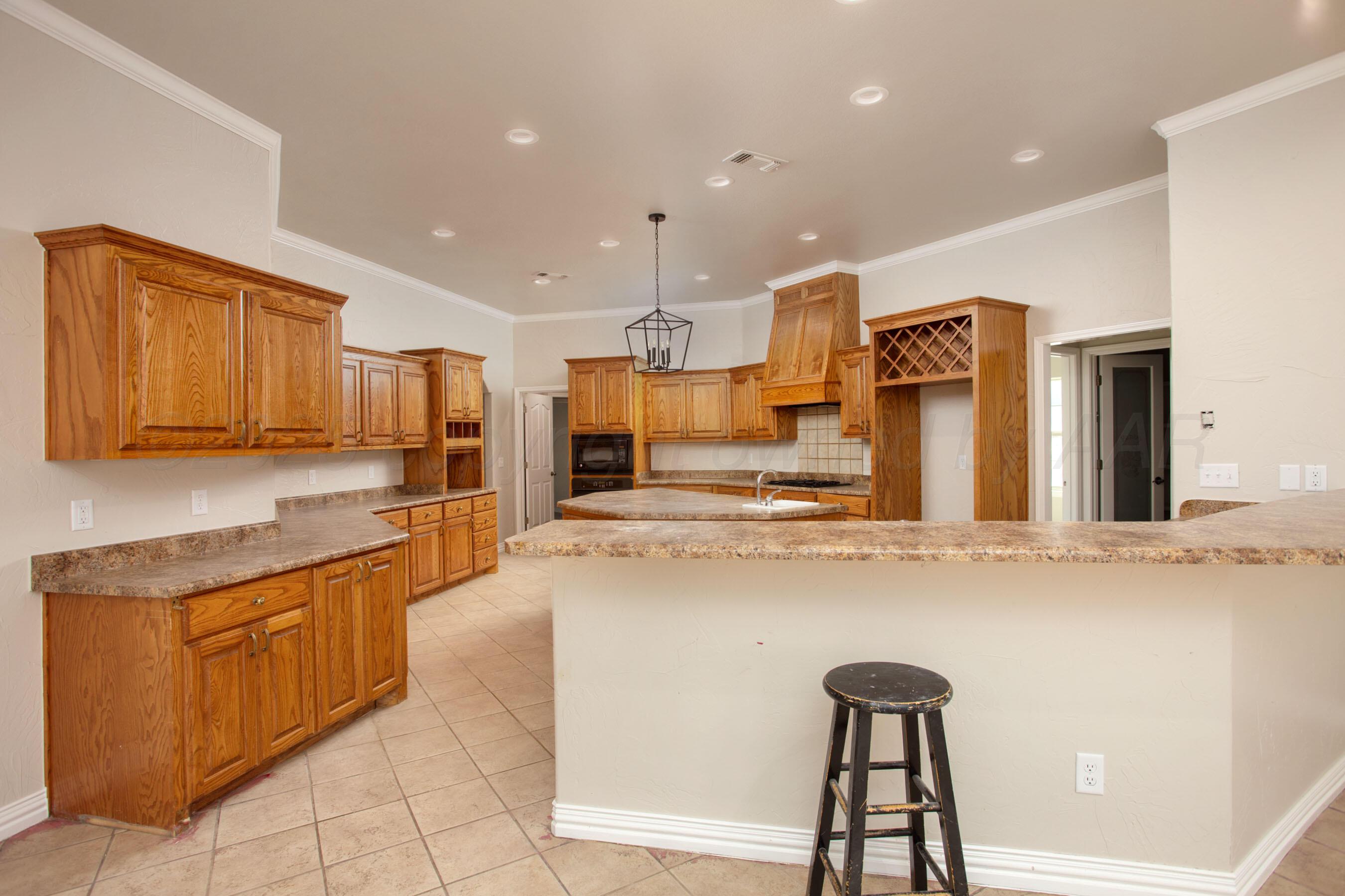 9050 Greyhawk Road Amarillo, TX 79119 - Photo 4 of 55 a kitchen with stainless steel appliances granite countertop a sink and a refrigerator