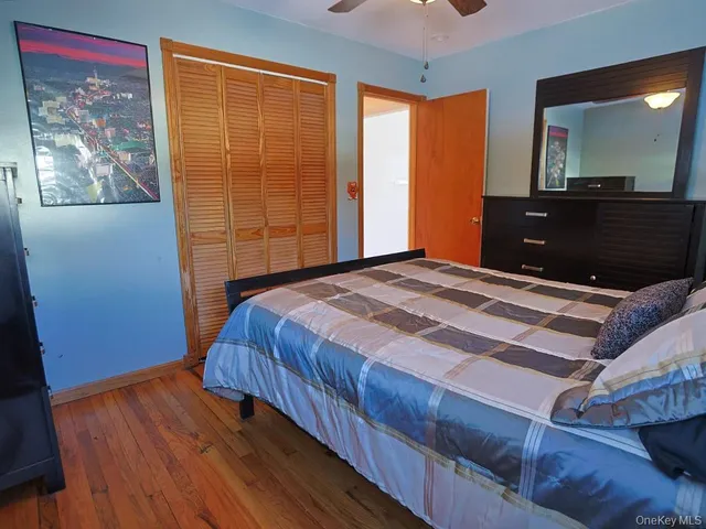 a bedroom with a bed and a mirror on the dresser