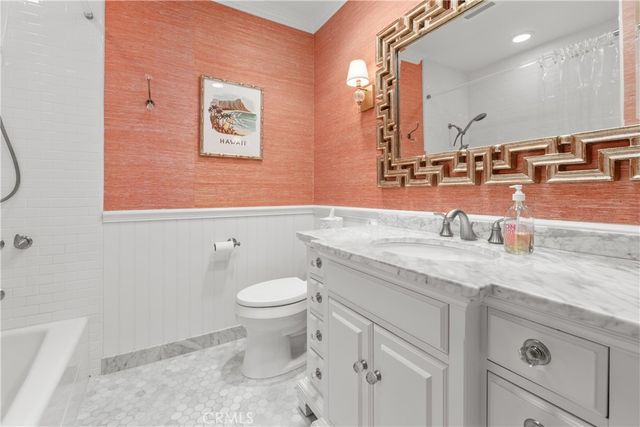 a bathroom with a granite countertop sink mirror vanity and toilet