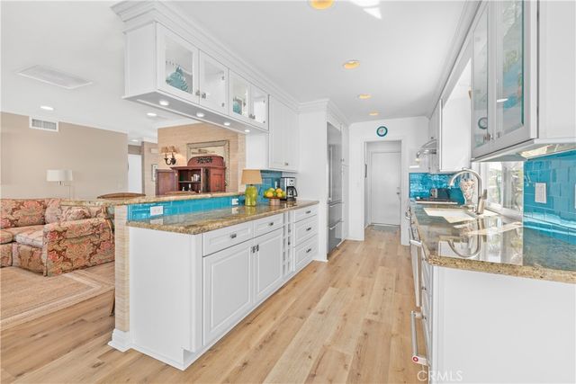 a kitchen with stainless steel appliances granite countertop a lot of counter top space and wooden floor