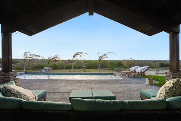 a view of a roof deck with couches and sky view