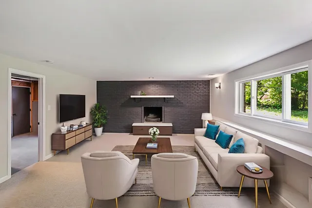 a living room with furniture a flat screen tv and a large window