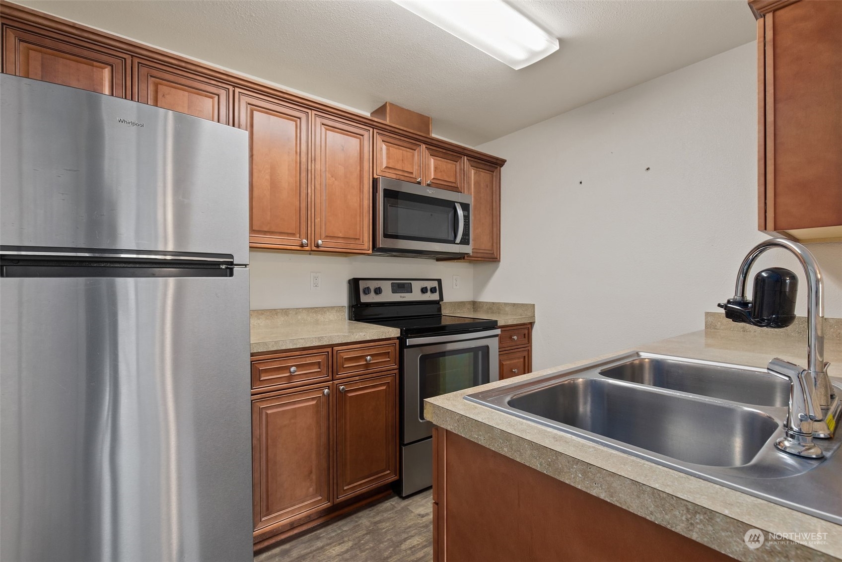 11002 Southeast Petrovitsky Road, Unit E101 Renton, WA 98055 - Photo 11 of 40 a kitchen with a refrigerator sink and stove