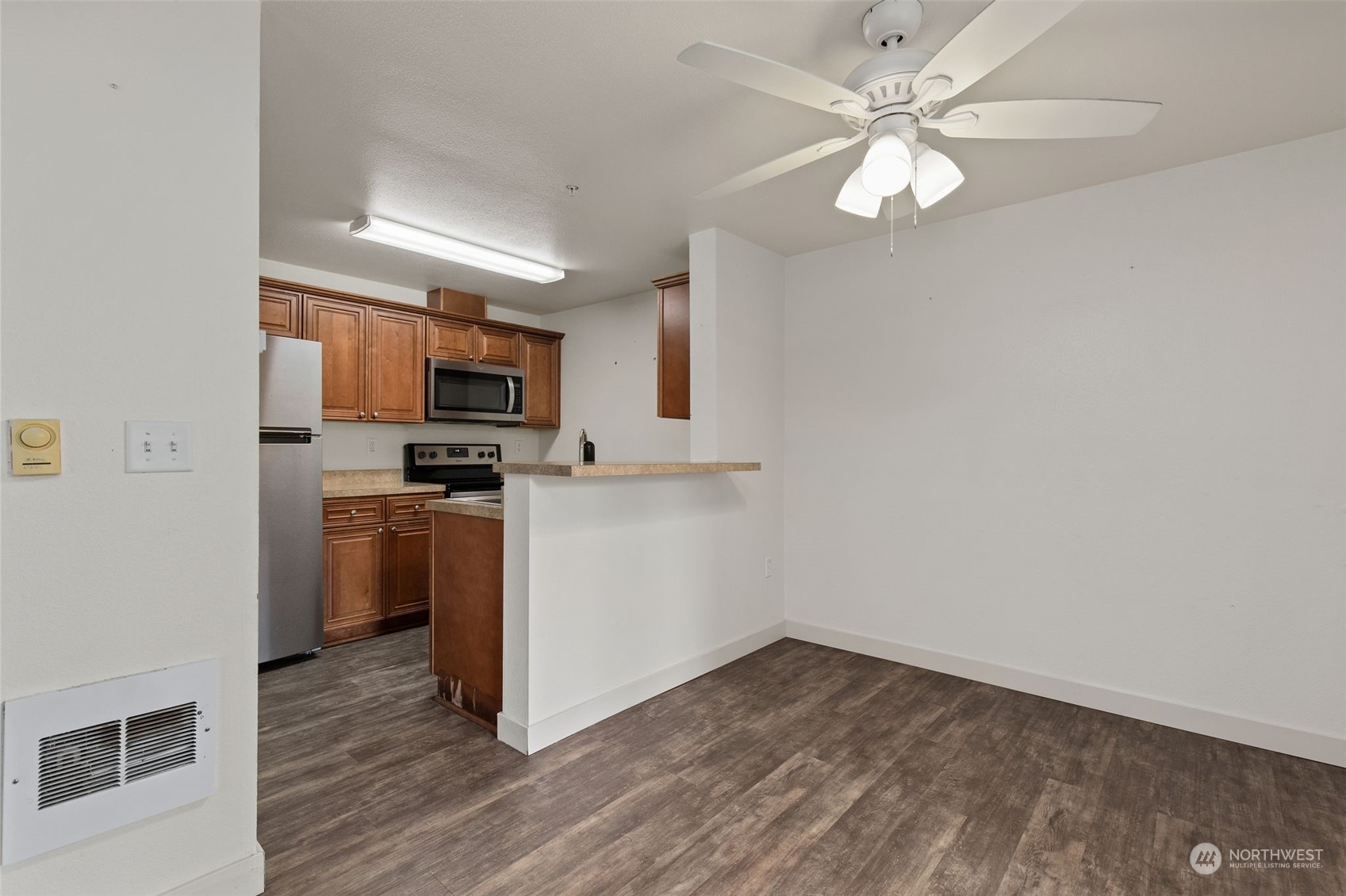 11002 Southeast Petrovitsky Road, Unit E101 Renton, WA 98055 - Photo 8 of 40 a view of a kitchen with a sink a ceiling fan and refrigerator