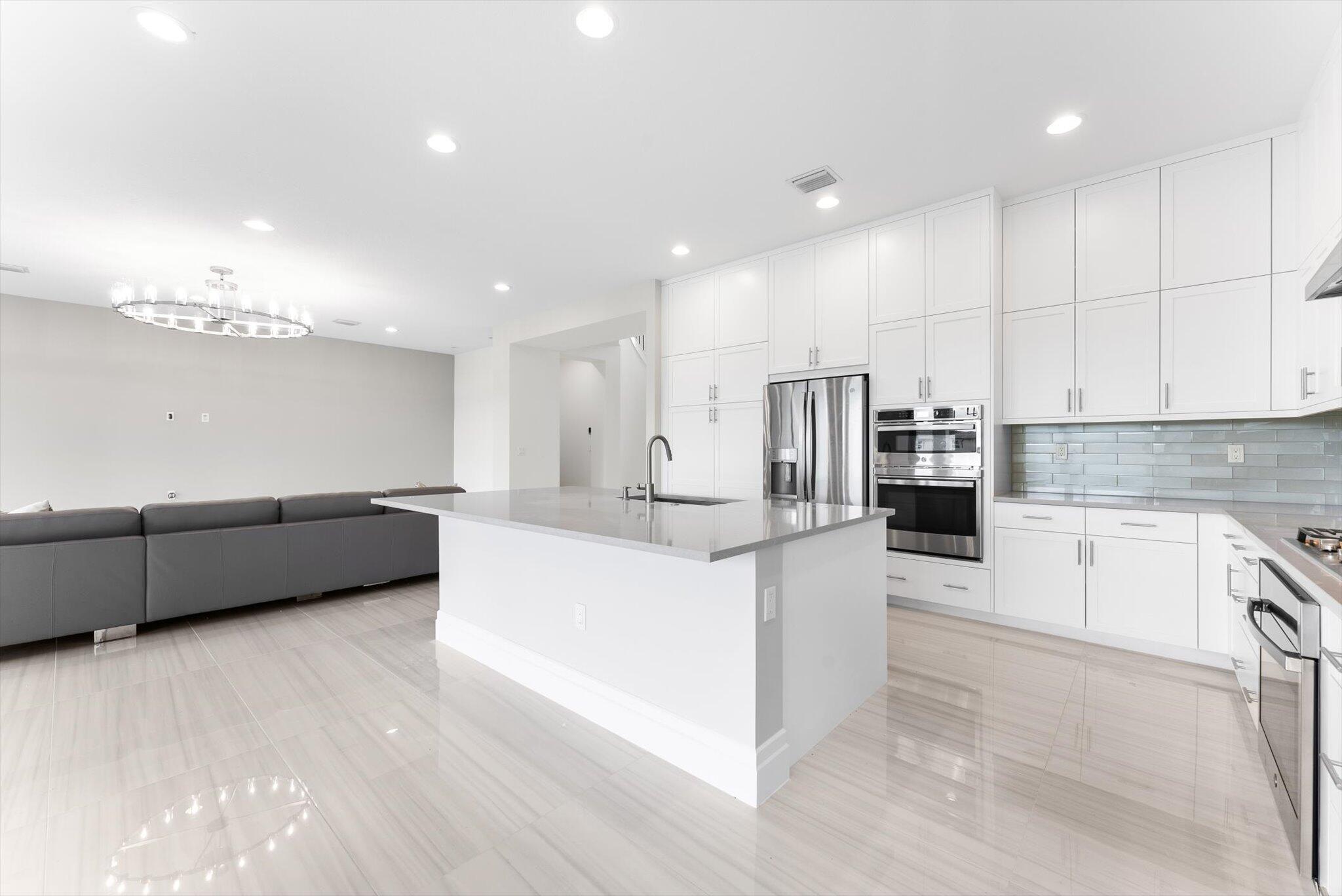 20107 Pacific Dunes Drive Boca Raton, FL 33434 - Photo 20 of 85 a large white kitchen with kitchen island a sink a center island stainless steel appliances and a cabinets