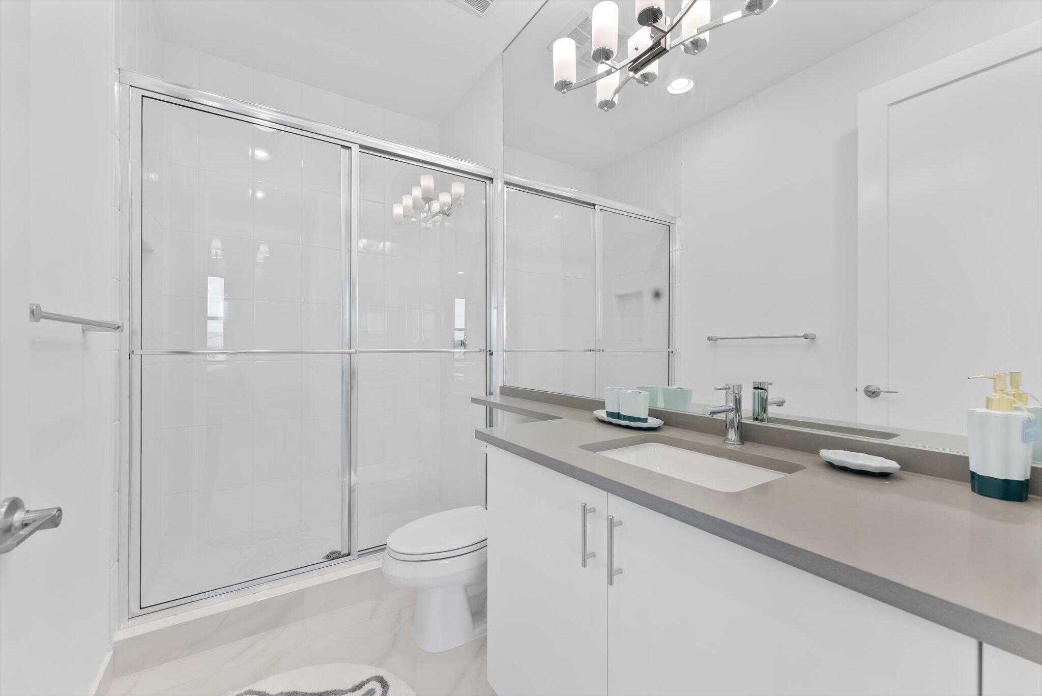 20107 Pacific Dunes Drive Boca Raton, FL 33434 - Photo 42 of 85 a bathroom with a granite countertop sink a toilet and mirror