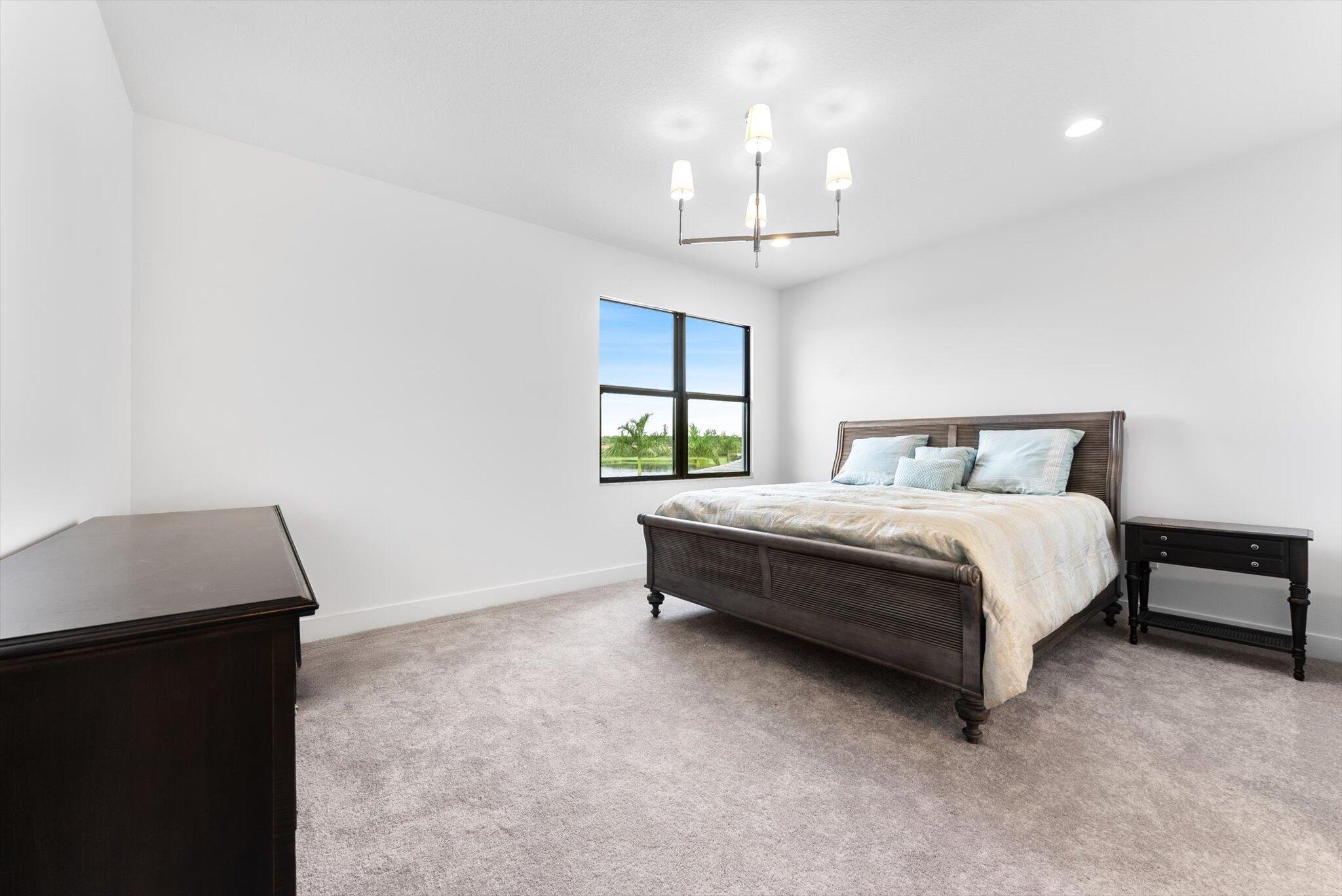 20107 Pacific Dunes Drive Boca Raton, FL 33434 - Photo 43 of 85 a spacious bedroom with a bed and a window
