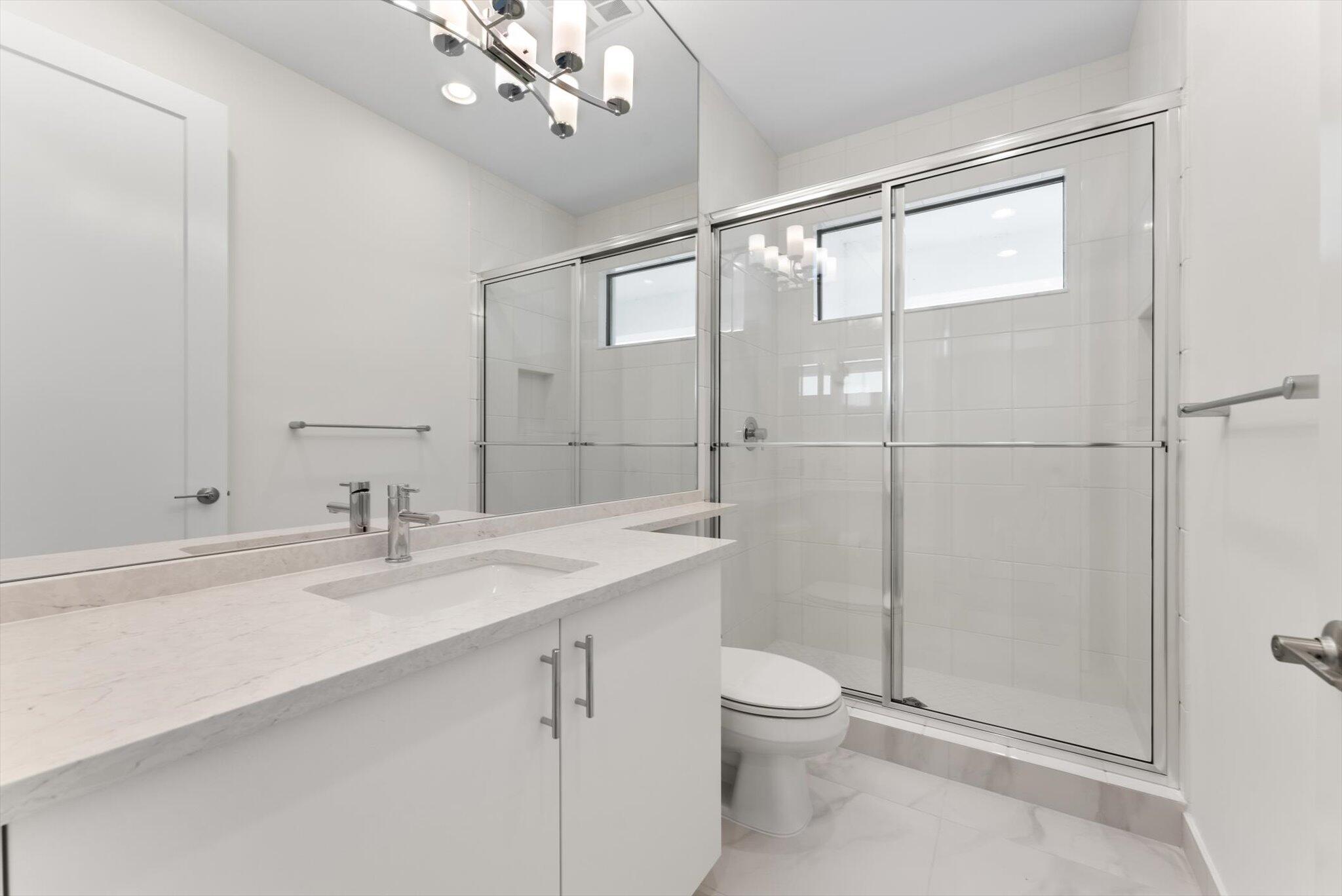 20107 Pacific Dunes Drive Boca Raton, FL 33434 - Photo 44 of 85 a bathroom with a granite countertop sink a toilet and shower