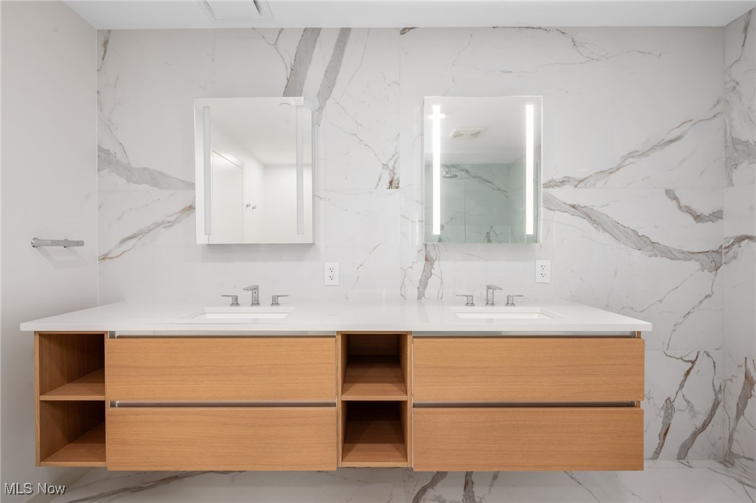 22700 Lake Road, Unit 204 Rocky River, OH 44116 - Photo 17 of 31 Bathroom featuring light marble finish floors, stone wall, and double vanity