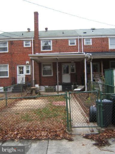 8038 Kavanagh Road Dundalk, MD 21222 - Photo 5 of 10 a view of a brick house with many windows next to a yard