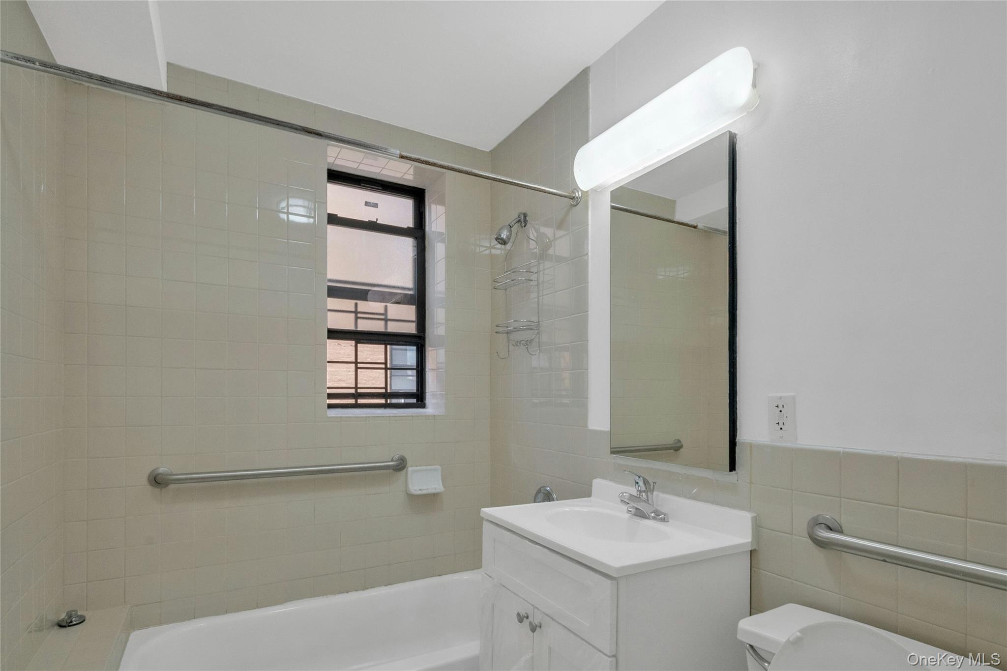 2023 Belmont Avenue, Unit 5A Bronx, NY 10457 - Photo 17 of 19 a bathroom with a sink toilet and shower