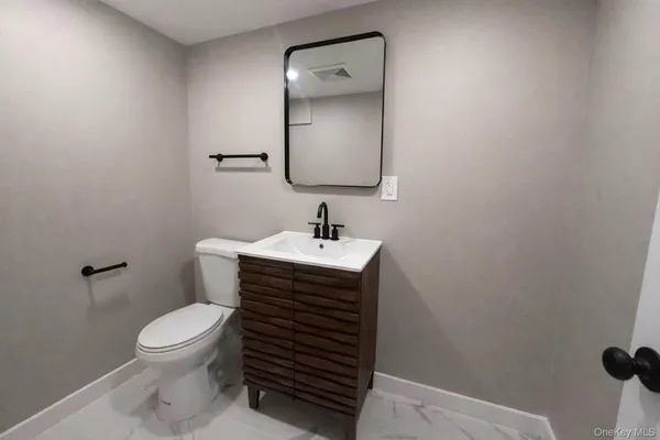 a bathroom with a toilet a sink and mirror