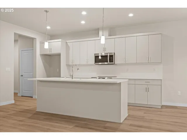 a kitchen with kitchen island white cabinets and stainless steel appliances