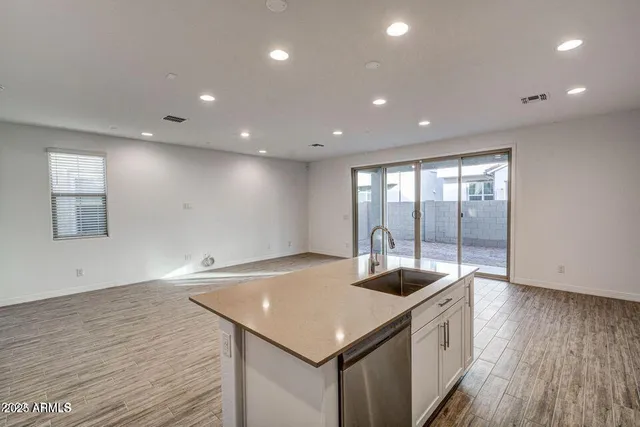 a kitchen with a sink and wooden floor