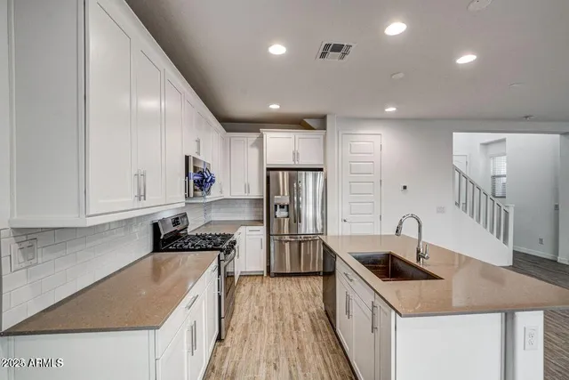 a kitchen with stainless steel appliances granite countertop a sink stove and refrigerator
