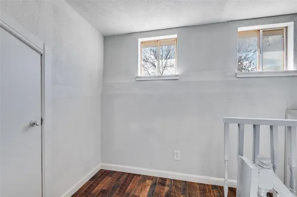 a view of hallway with window and wooden floor