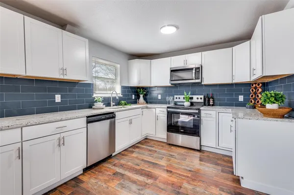 a kitchen with granite countertop white cabinets and white appliances