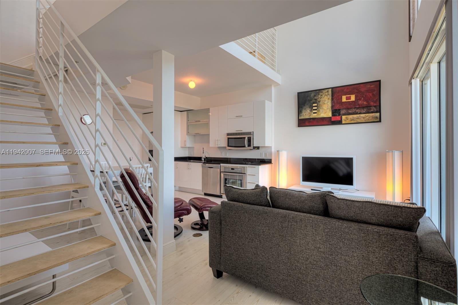 60 Southwest 13th Street, Unit 4211 Miami, FL 33130 - Photo 7 of 17 a living room with furniture a fireplace and a flat screen tv
