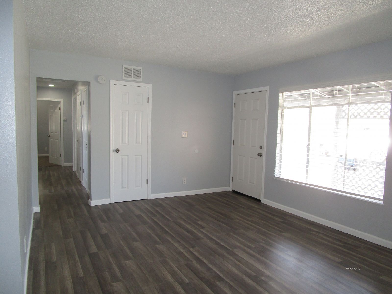 240 North Norma Street Ridgecrest, CA 93555 - Photo 3 of 6 a view of an empty room with wooden floor and a window