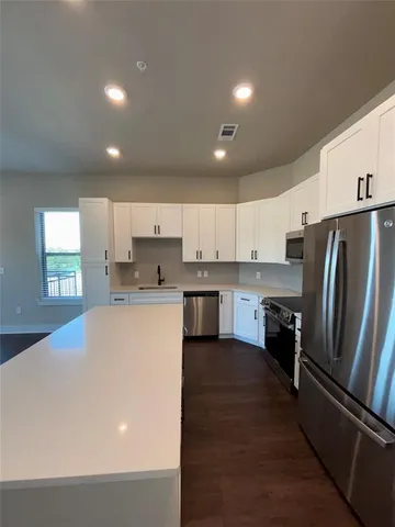 a kitchen with stainless steel appliances a refrigerator sink and cabinets