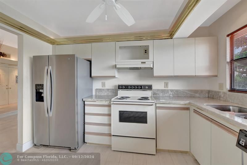 9477 Burlington Place Boca Raton, FL 33434 - Photo 23 of 40 a kitchen with cabinets appliances and a sink