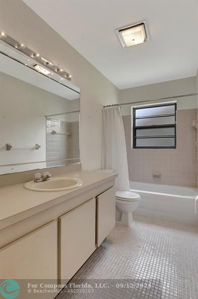 9477 Burlington Place Boca Raton, FL 33434 - Photo 29 of 40 a bathroom with a granite countertop sink a toilet a mirror and bathtub