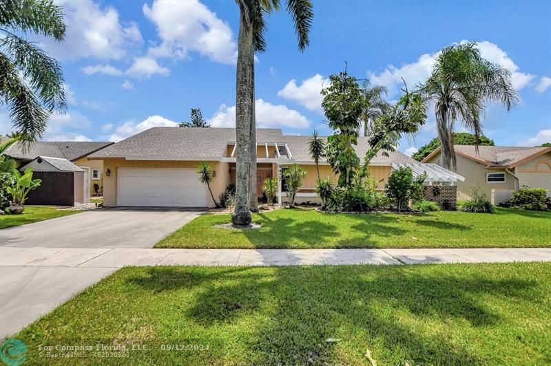 9477 Burlington Place Boca Raton, FL 33434 - Photo 3 of 40 a front view of a house with a garden and plants