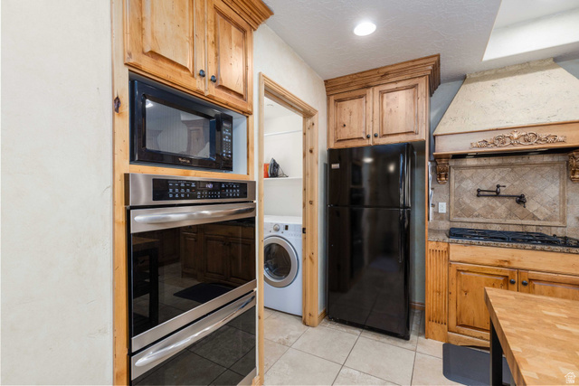 5168 Fairview Loop, Unit C604 Eden, UT 84310 - Photo 8 of 53 Kitchen featuring black appliances, backsplash, washer / clothes dryer, butcher block counters, and light tile patterned flooring
