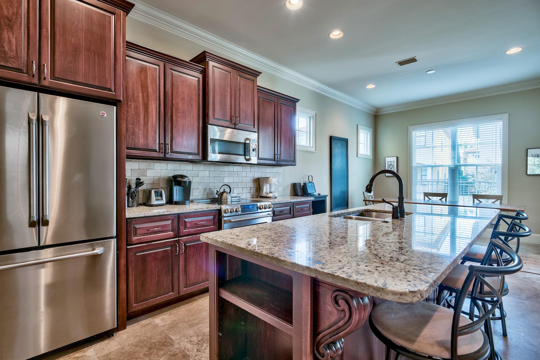 1973 Baytowne Loop Miramar Beach, FL 32550 - Photo 7 of 40 a kitchen with granite countertop a table chairs microwave and refrigerator