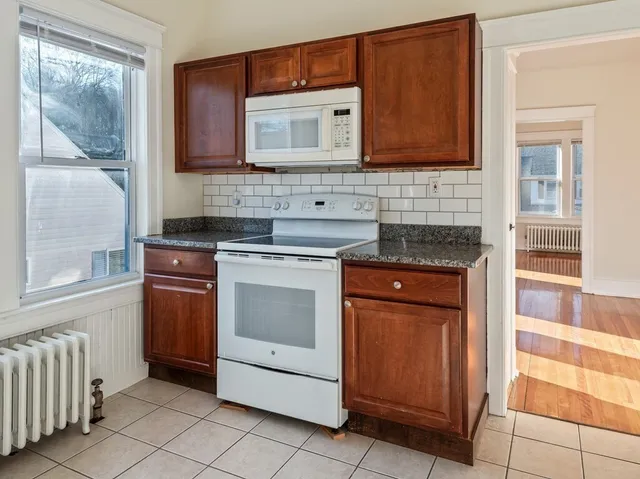 a kitchen with stainless steel appliances granite countertop a stove microwave and cabinets