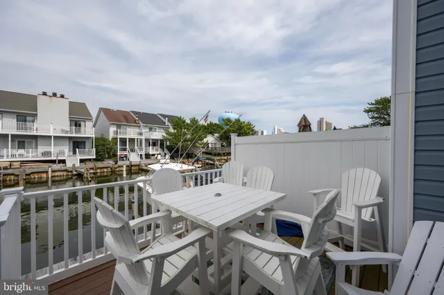 a view of a rooftop deck with chairs and wooden floor