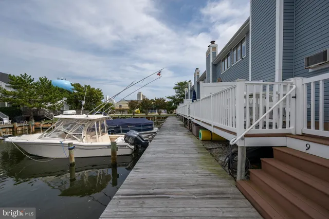 a view of a house with wooden deck and a lake view