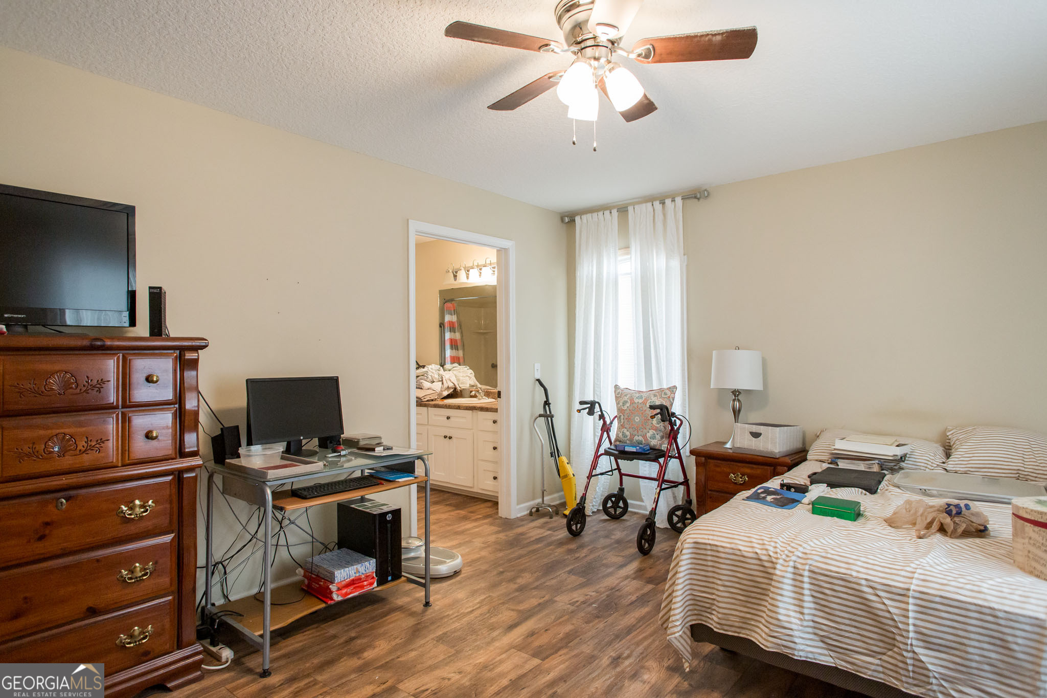 920 Wilfred Street Waycross, GA 31503 - Photo 14 of 17 a bedroom with bed a flat tv screen and a bookshelf