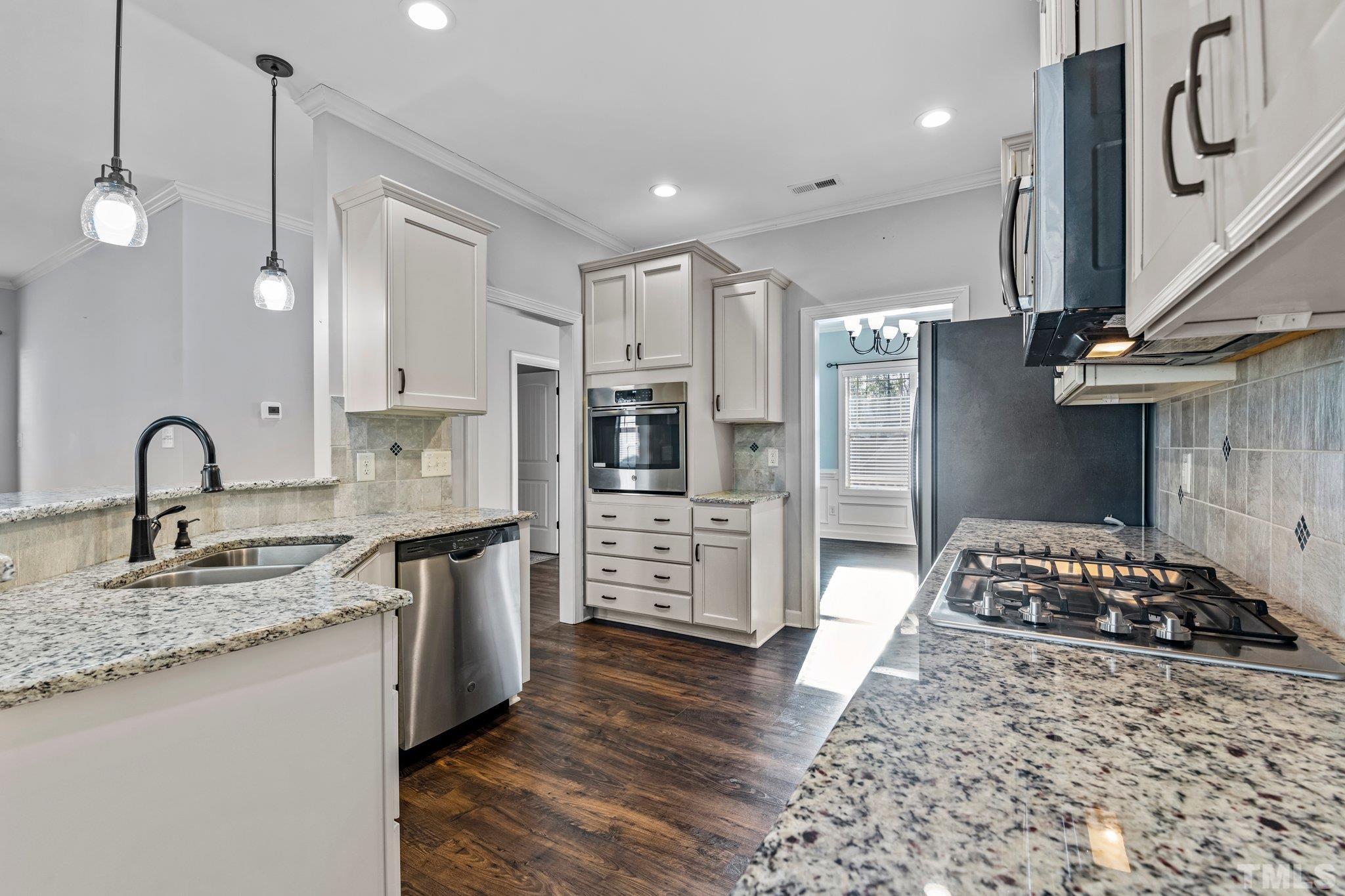 97 Thunder Ridge Drive Garner, NC 27529 - Photo 11 of 33 a kitchen with stainless steel appliances granite countertop a stove a sink and a refrigerator