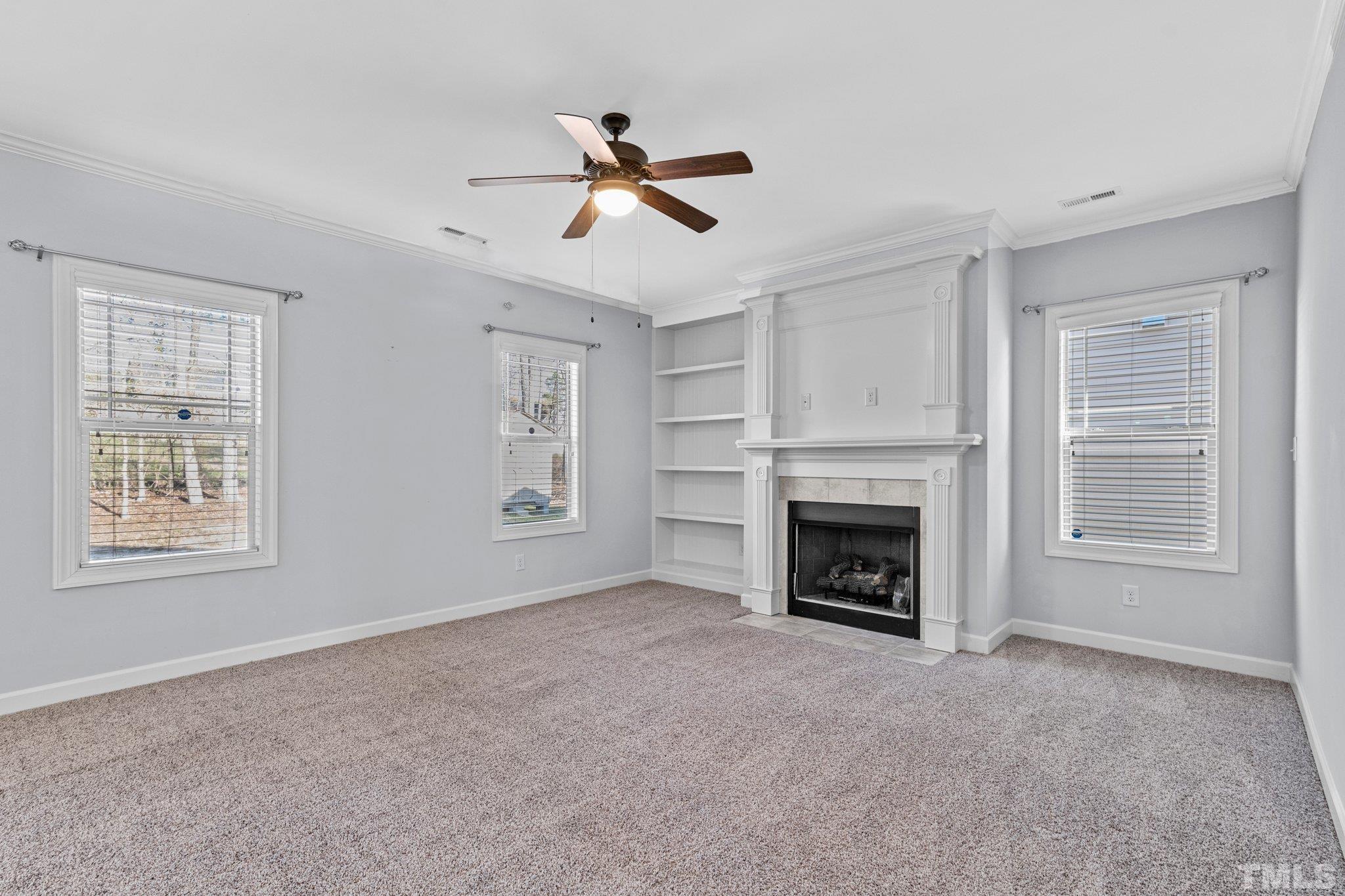 97 Thunder Ridge Drive Garner, NC 27529 - Photo 14 of 33 a view of a livingroom with a fireplace a ceiling fan and windows