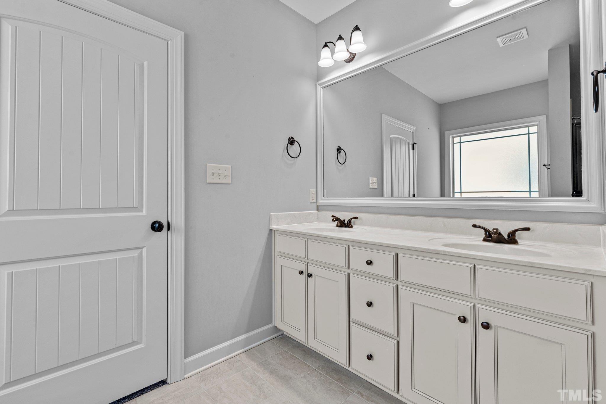 97 Thunder Ridge Drive Garner, NC 27529 - Photo 21 of 33 a bathroom with a double vanity sink and a mirror