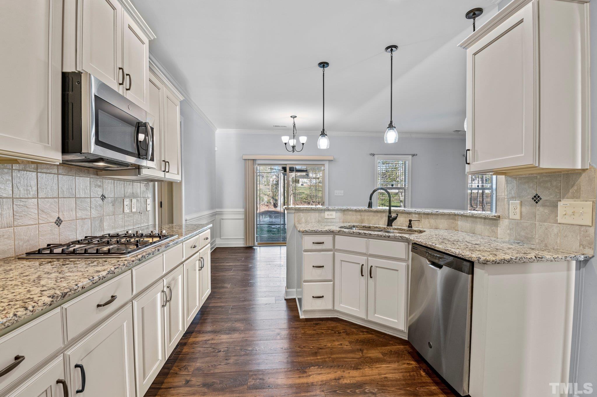97 Thunder Ridge Drive Garner, NC 27529 - Photo 9 of 33 a kitchen with stainless steel appliances granite countertop a sink a stove oven a counter top space and cabinets