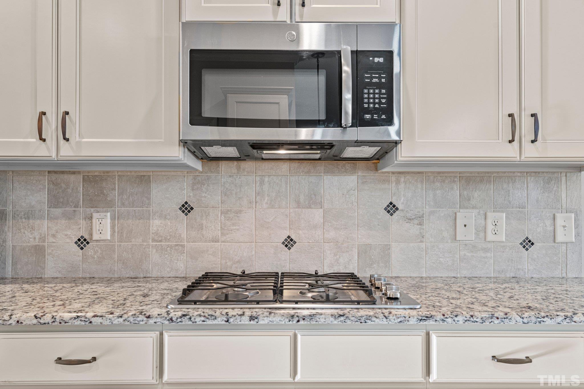 97 Thunder Ridge Drive Garner, NC 27529 - Photo 10 of 33 a kitchen with granite countertop white cabinets and stainless steel appliances