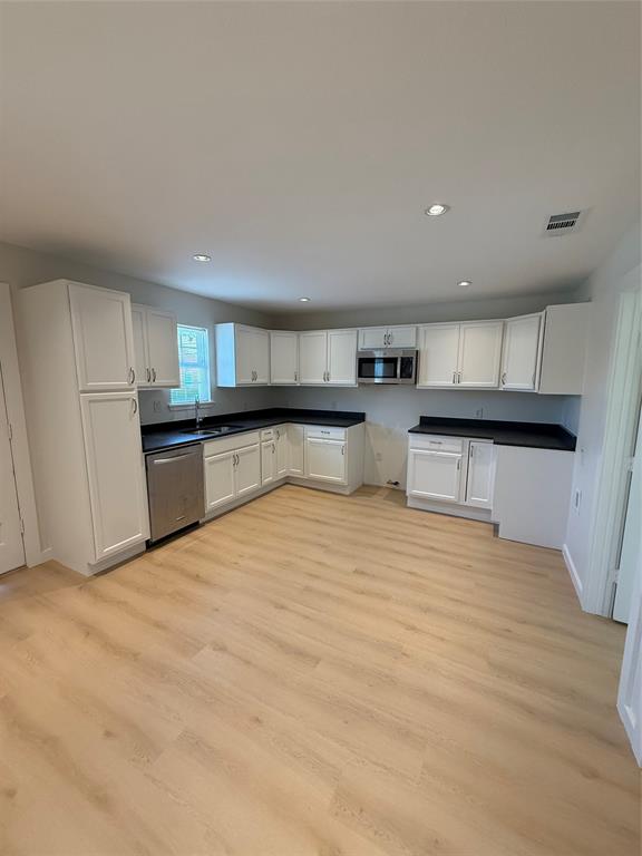 a large kitchen with stainless steel appliances granite countertop a refrigerator and a sink