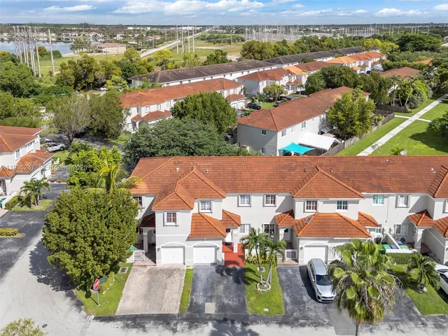 an aerial view of residential houses with outdoor space and ocean view
