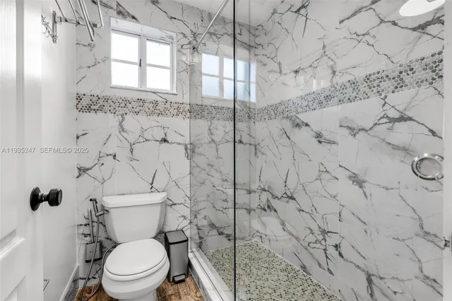 a white toilet sitting next to a shower