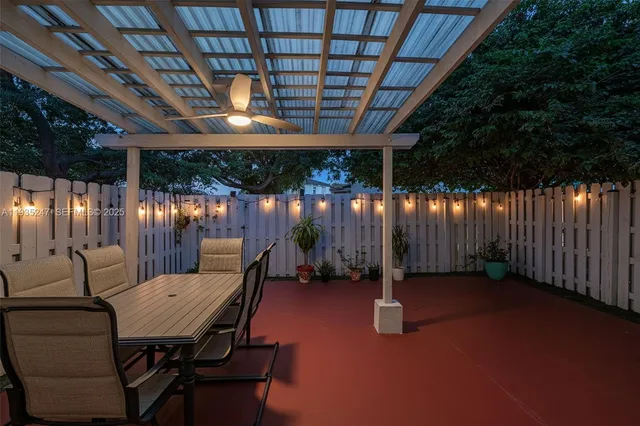 a view of a patio with table and chairs with wooden fence
