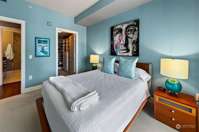 a bedroom with a bed and painting on the wall
