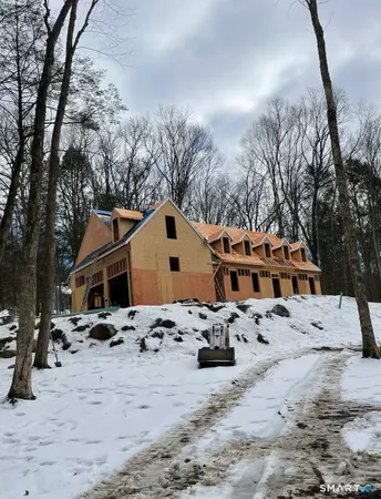 a front view of a house with snow on the road