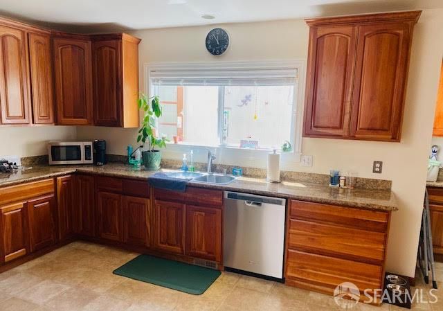 a kitchen with stainless steel appliances granite countertop wooden cabinets a sink and dishwasher