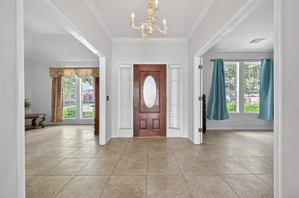a view of a hallway with windows and chandelier