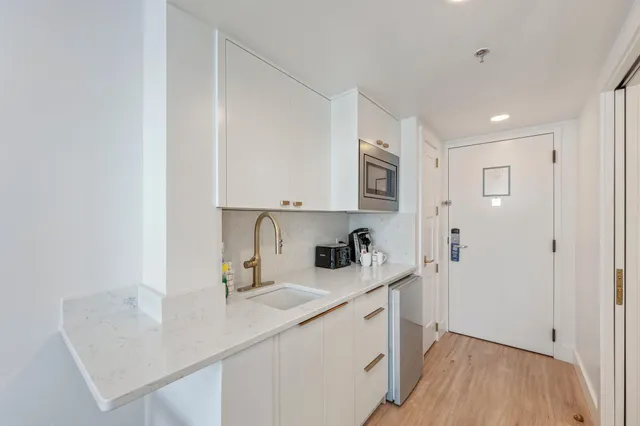 a kitchen with a sink cabinets and wooden floor